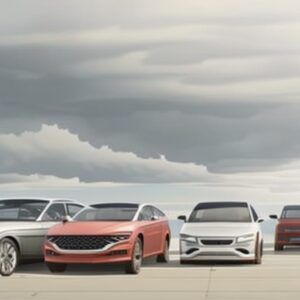 A group of cars parked in front of some clouds.